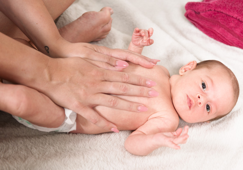 image of baby during infant massage session on a towel.